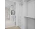 Walk-in closet with built-in shelving and drawers adjoining bathroom with white tile floors at 1750 Wewatta St # 1501, Denver, CO 80202