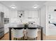 White kitchen with stainless appliances, modern countertops and backsplash, and a center island with seating at 1750 Wewatta St # 1501, Denver, CO 80202