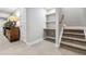 Finished basement area features built-in shelving, storage, and a staircase to the upper level at 8565 E 50Th Dr, Denver, CO 80238