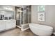 Modern bathroom boasts a soaking tub, glass shower, and a dual sink vanity at 8565 E 50Th Dr, Denver, CO 80238