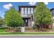 Elegant home showcasing lush greenery, manicured flower beds, and a unique gray brick exterior at 8565 E 50Th Dr, Denver, CO 80238
