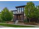 Modern two-story home featuring a manicured lawn, tasteful landscaping, and a stylish brick facade at 8565 E 50Th Dr, Denver, CO 80238