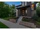 Attractive home featuring a charming front porch, colorful landscaping, and an eye-catching brick exterior at 8565 E 50Th Dr, Denver, CO 80238