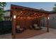 Cozy backyard pergola with outdoor lighting, comfortable seating, and a tranquil ambiance for relaxation at 8565 E 50Th Dr, Denver, CO 80238