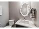 Stylish powder room featuring a unique mirror, modern sink, and neutral wall color at 8565 E 50Th Dr, Denver, CO 80238