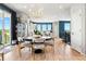 Bright dining area with a sleek round table, modern chandelier, and hardwood floors at 15020 Cast Pebble Cir, Parker, CO 80134