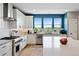 White kitchen featuring stainless steel appliances, an island with seating, and modern finishes at 15020 Cast Pebble Cir, Parker, CO 80134