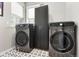 Modern laundry room featuring front-load washer and dryer, sleek storage cabinet and stylish tile floors at 15020 Cast Pebble Cir, Parker, CO 80134