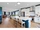 Spacious kitchen featuring white cabinets, an island with seating, and an open living space at 15020 Cast Pebble Cir, Parker, CO 80134
