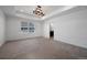 Spacious bedroom with a tray ceiling, neutral carpet, and an ensuite bathroom at 1041 W Witherspoon Dr, Elizabeth, CO 80107