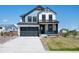Two-story home boasts a gray and white exterior, attached two-car garage, and a cozy front porch at 1041 W Witherspoon Dr, Elizabeth, CO 80107