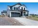 Two-story home boasts a gray and white exterior, attached two-car garage, and a cozy front porch at 1041 W Witherspoon Dr, Elizabeth, CO 80107