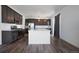 Modern kitchen with a white island, stainless steel appliances, and dark cabinetry, complemented by stylish dark flooring at 1041 W Witherspoon Dr, Elizabeth, CO 80107