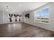 Spacious living room with dark wood flooring, white walls, tv, and windows with curtains at 1041 W Witherspoon Dr, Elizabeth, CO 80107