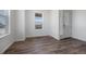 Open-concept living room with dark wood flooring, white walls, and natural light, leading to the front door at 1041 W Witherspoon Dr, Elizabeth, CO 80107