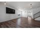 Bright living room featuring a large flat screen television, wood floors and natural light at 1041 W Witherspoon Dr, Elizabeth, CO 80107