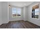 Open-concept living room with dark wood flooring, white walls, and natural light coming through windows at 1041 W Witherspoon Dr, Elizabeth, CO 80107