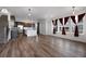 Open-concept living space featuring dark wood floors, white walls, a kitchen, stairs, and abundant natural light at 1041 W Witherspoon Dr, Elizabeth, CO 80107