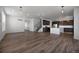 Spacious living area with dark wood floors, a kitchen, stairs, and white walls at 1041 W Witherspoon Dr, Elizabeth, CO 80107