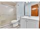 Bathroom featuring a shower, a toilet, a mirror, a sink, and white cabinets at 1500 S Wolcott Ct, Denver, CO 80219