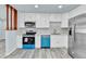 Bright kitchen featuring white cabinets, stainless steel appliances and modern countertops at 1500 S Wolcott Ct, Denver, CO 80219