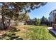 Fenced backyard with green grass and mature trees, offering a private outdoor space at 4969 Thorndike Ave, Castle Rock, CO 80104