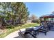 Backyard featuring a shaded stone patio, outdoor seating, lush green lawn and mature trees at 4969 Thorndike Ave, Castle Rock, CO 80104