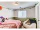 Bright bedroom featuring neutral walls, pink bedding, chair, and decorative garland at 4969 Thorndike Ave, Castle Rock, CO 80104