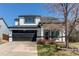 Charming two-story home featuring a well-manicured lawn, black trim, a black garage door, and a concrete driveway at 4969 Thorndike Ave, Castle Rock, CO 80104