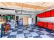 Spacious garage with checkered flooring, bright red cabinets, and ample storage space at 4969 Thorndike Ave, Castle Rock, CO 80104