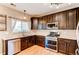Well-equipped kitchen with stainless steel appliances, dark wood cabinets, and bright lighting fixtures at 4969 Thorndike Ave, Castle Rock, CO 80104