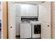 Laundry room with side by side washer and dryer and white cabinets for storage at 4969 Thorndike Ave, Castle Rock, CO 80104