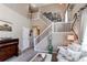 Relaxing living room with a vaulted ceiling, white staircase, wall decor, comfortable sofa, and a view of the entry at 4969 Thorndike Ave, Castle Rock, CO 80104