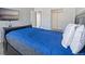 Bedroom with a TV, bed with blue comforter, and carpeted floors at 10970 W Florida Ave # 225, Lakewood, CO 80232