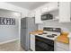 Well lit kitchen with stainless steel refrigerator and white cabinets at 10970 W Florida Ave # 225, Lakewood, CO 80232