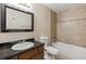 Bathroom with a tile backsplash over tub, dark countertop and wood cabinets at 331 Wright St # 108, Lakewood, CO 80228