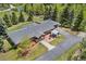 An aerial view of a ranch-style home with a brick patio, pergola, and lush landscaping surrounded by mature trees at 27436 Kennedy Gulch Rd, Conifer, CO 80433