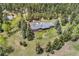 Charming ranch-style home nestled on a sprawling lot surrounded by lush greenery and mature trees at 27436 Kennedy Gulch Rd, Conifer, CO 80433