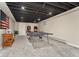 Finished basement featuring neutral walls and carpet and a ping pong table with decorative shelving at 27436 Kennedy Gulch Rd, Conifer, CO 80433