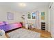 Cozy bedroom with colorful bedding, a wooden floor, and natural light from the window at 27436 Kennedy Gulch Rd, Conifer, CO 80433