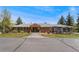 Charming brick ranch-style home featuring a welcoming front porch and pergola covered patio area at 27436 Kennedy Gulch Rd, Conifer, CO 80433
