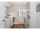 Well-lit laundry room with gray cabinets, modern washer/dryer units, and wood-look floors at 27436 Kennedy Gulch Rd, Conifer, CO 80433