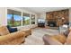 Cozy living room with a stone fireplace, large windows with mountain views, and comfortable seating at 27436 Kennedy Gulch Rd, Conifer, CO 80433