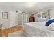 Bright bedroom featuring wood floors, a large bed, a wood dresser, a window and a sliding glass shower door at 27436 Kennedy Gulch Rd, Conifer, CO 80433