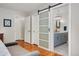 Bedroom view to sliding barn doors and ensuite bathroom with modern finishes at 27436 Kennedy Gulch Rd, Conifer, CO 80433