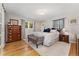 Bedroom featuring wood floors, neutral colored walls and decor, a large bed, a wood dresser and a window at 27436 Kennedy Gulch Rd, Conifer, CO 80433