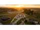 Aerial view of luxury estate with a long driveway, white fences, lush landscaping, and stunning sunset at 2495 Red Hawk Pl, Broomfield, CO 80023