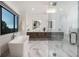 Sleek bathroom showcasing a modern soaking tub, double vanity with illuminated mirrors, and a spacious glass shower at 2495 Red Hawk Pl, Broomfield, CO 80023