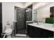 Modern bathroom features a glass enclosed shower with striking dark tiling and a sleek vanity with contrasting white countertop at 2495 Red Hawk Pl, Broomfield, CO 80023