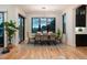 Modern dining room with a sleek chandelier, large windows, and seating for eight, perfect for entertaining at 2495 Red Hawk Pl, Broomfield, CO 80023